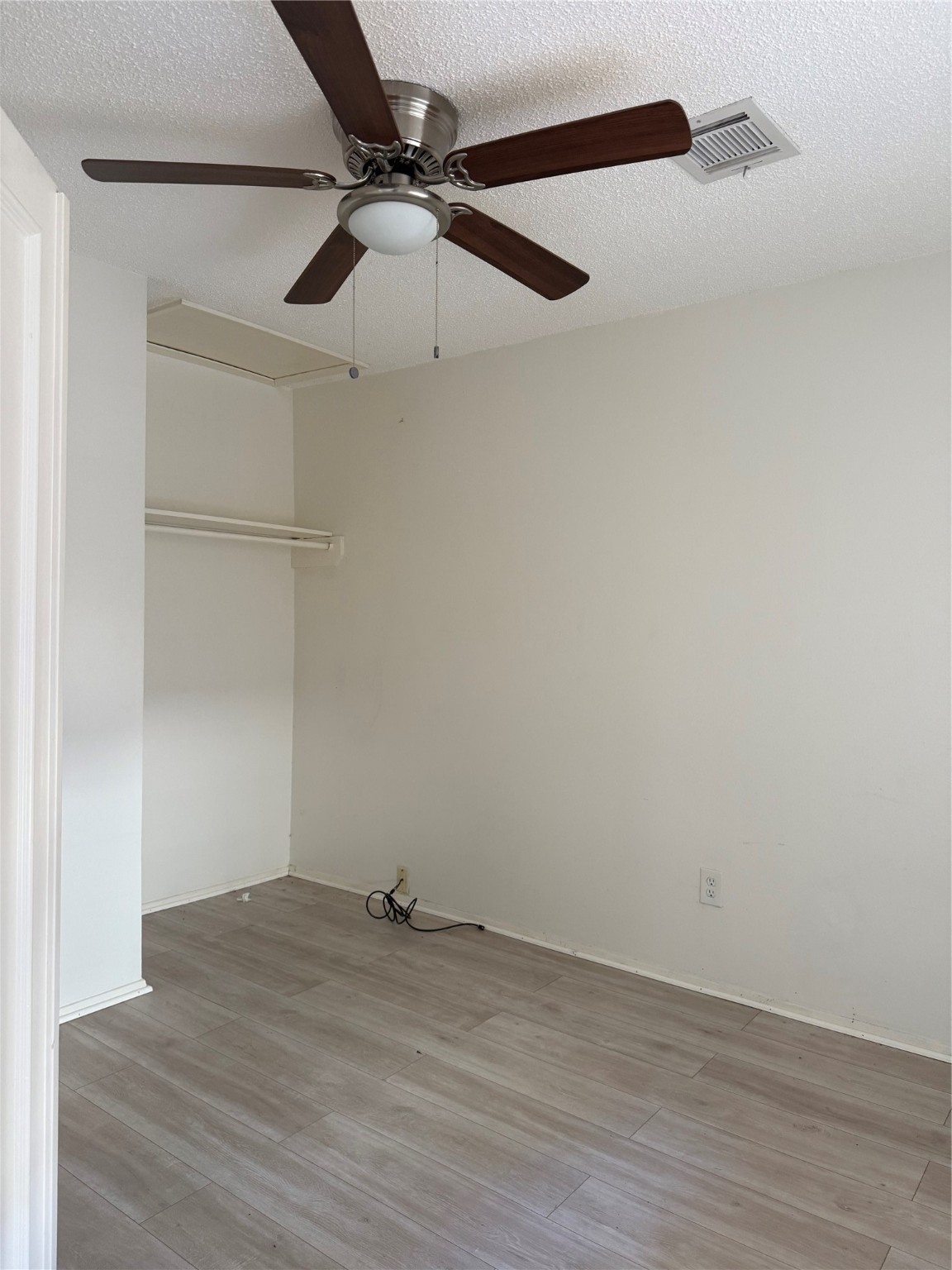 12550 Newbrook Drive Houston, TX 77072 - Photo 10 of 15 an empty room with a ceiling fan and wooden floor