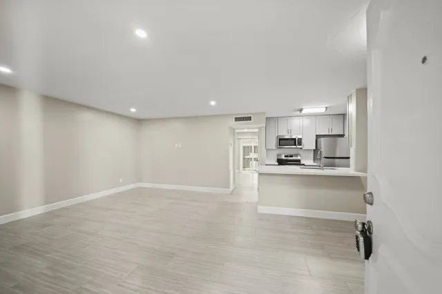 a view of kitchen with white cabinets and wooden floor