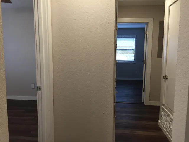 a view of a hallway with wooden floor and entryway