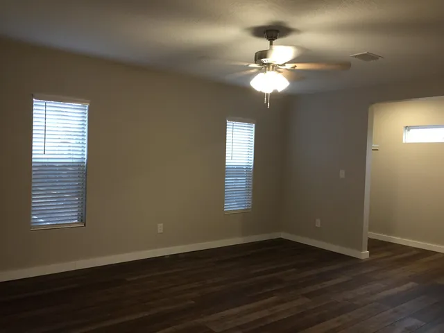 a view of a room with wooden floor and a window