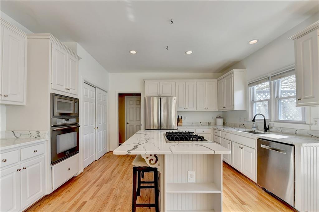 2152 Merrymount Drive Suwanee, GA 30024 - Photo 12 of 63 a kitchen that has a lot of cabinets in it with granite countertop stainless steel appliances