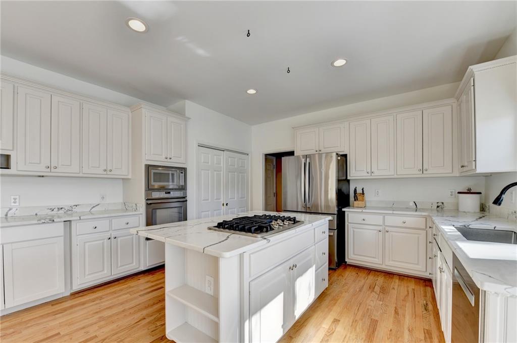 2152 Merrymount Drive Suwanee, GA 30024 - Photo 13 of 63 a kitchen with stainless steel appliances a refrigerator sink and white cabinets