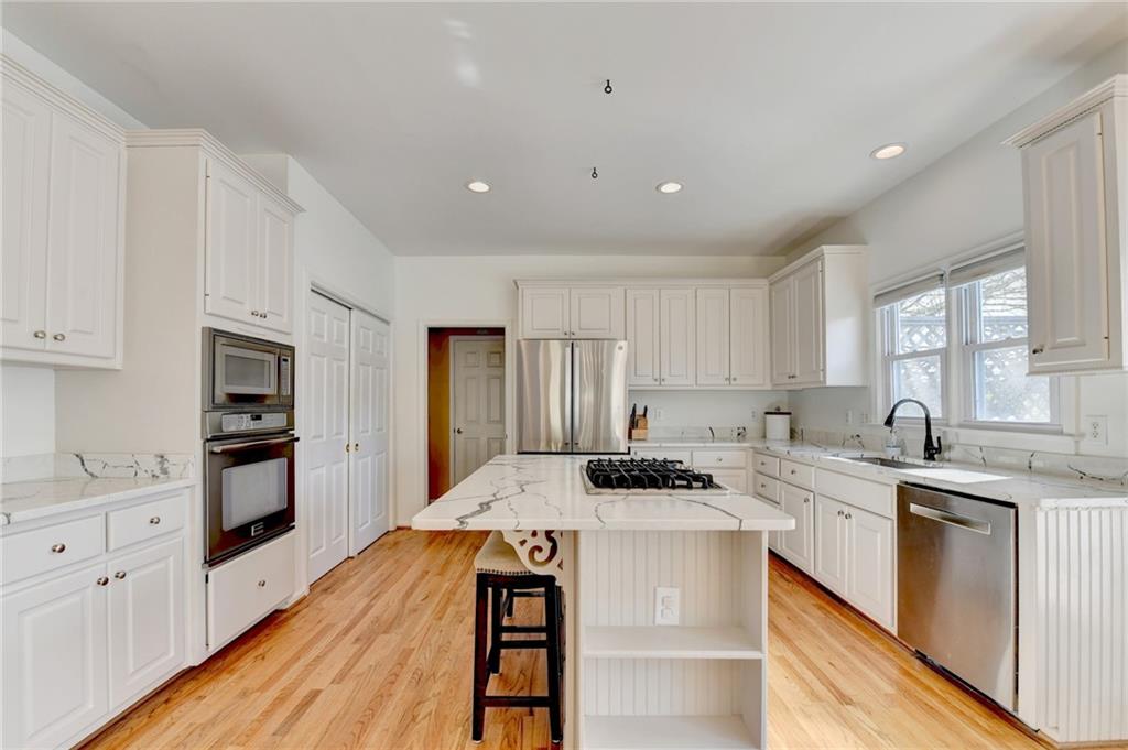 2152 Merrymount Drive Suwanee, GA 30024 - Photo 15 of 63 a kitchen that has a lot of cabinets in it with granite countertop stainless steel appliances and a sink