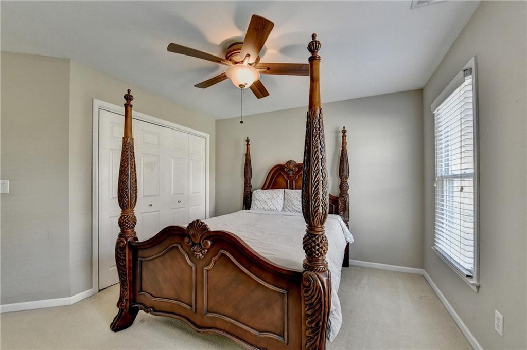 2152 Merrymount Drive Suwanee, GA 30024 - Photo 34 of 63 a bedroom with a bed and a chandelier