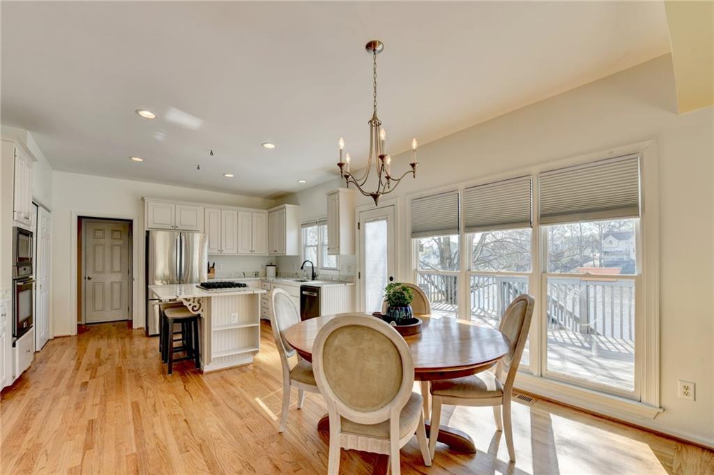 2152 Merrymount Drive Suwanee, GA 30024 - Photo 10 of 63 a dining room with furniture a chandelier and wooden floor