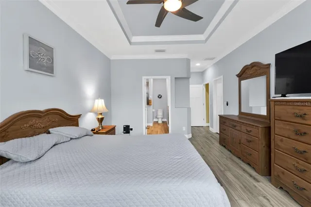 a bedroom with a bed and a flat tv screen on dresser
