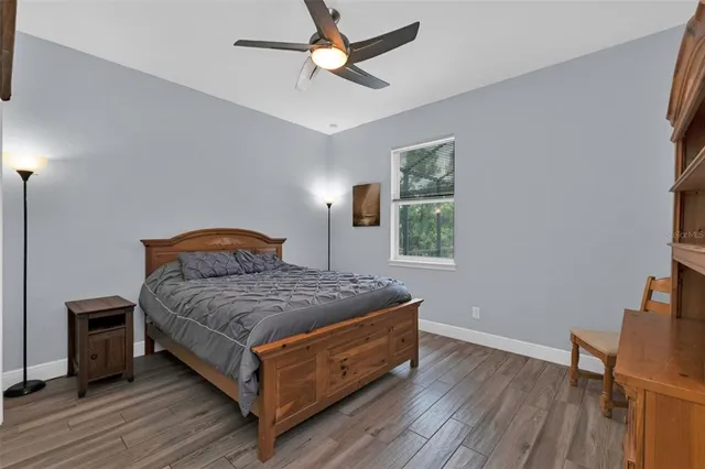 a bedroom with a bed and wooden floor