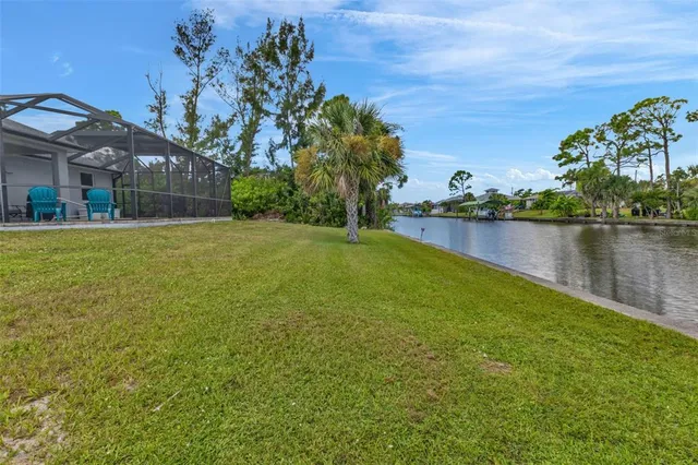 a view of a house with a yard and a pond
