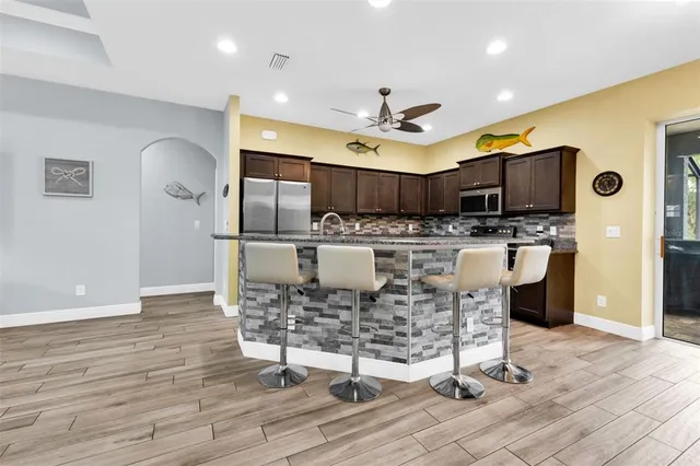 a kitchen with stainless steel appliances kitchen island granite countertop a stove and a refrigerator