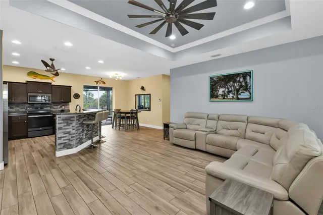 a living room with furniture kitchen and a wooden floor
