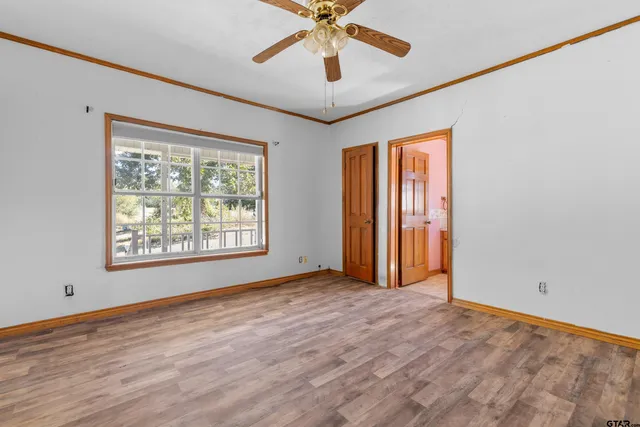a view of an empty room with window and wooden floor
