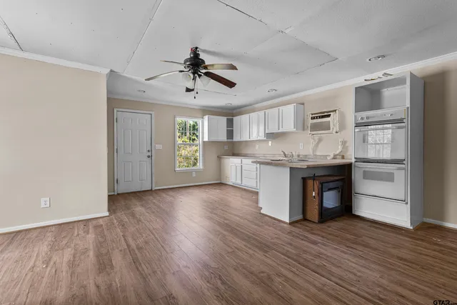 a kitchen with stainless steel appliances granite countertop a refrigerator a stove and a wooden floors