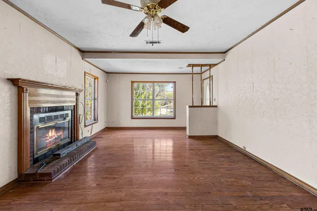 a view of an empty room with a fireplace and a window