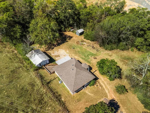 an aerial view of residential houses with outdoor space and trees
