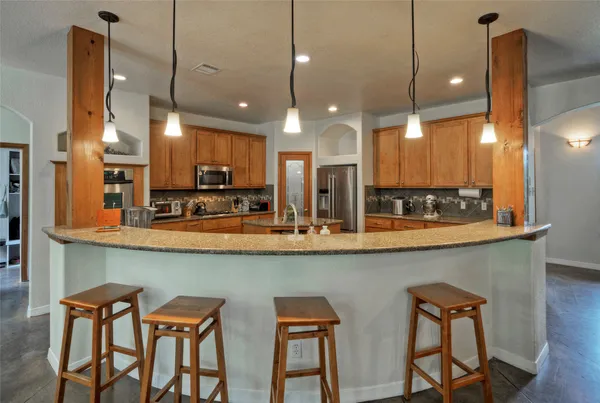 a kitchen with a table chairs refrigerator and microwave