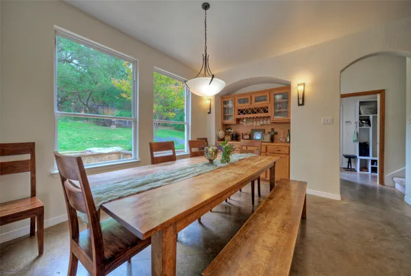 a dining room with wooden floor a chandelier a wooden table and chairs