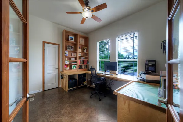 a view of a workspace with furniture and a window