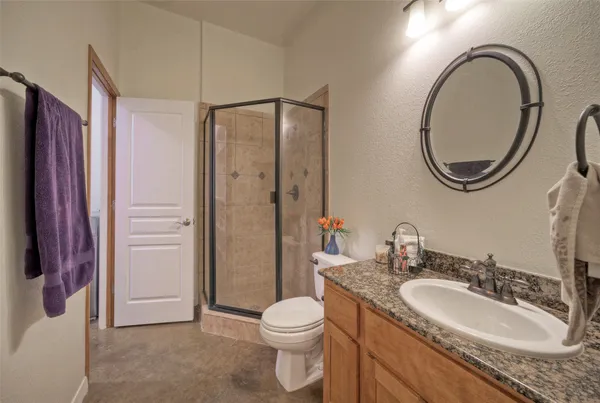 a bathroom with a granite countertop sink toilet and shower