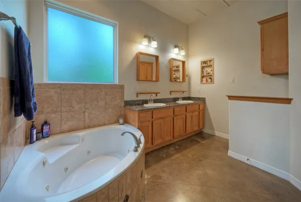 a bathroom with a tub sink and mirror
