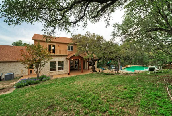 a view of a house with a big yard and large trees