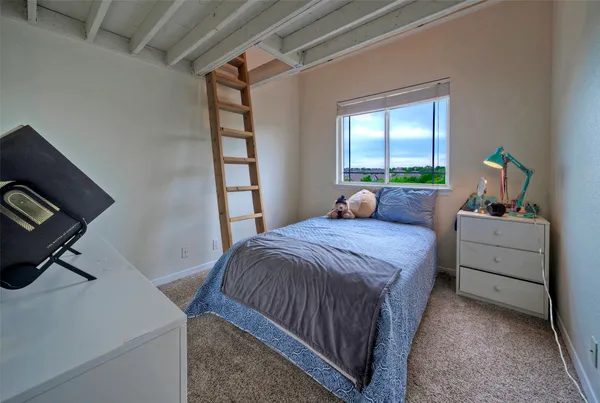 a bedroom with a bed a couch and a window