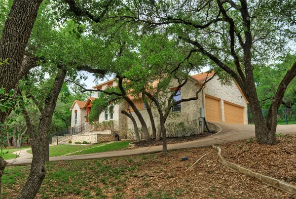 a view of a yard in front of a house with a tree