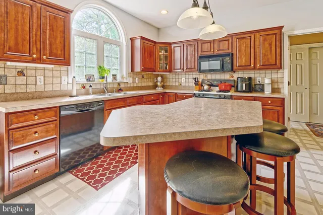 a kitchen with stainless steel appliances granite countertop a sink a stove a table and chairs