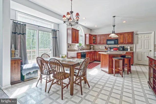 a dining hall with granite countertop a dining table chairs and a chandelier