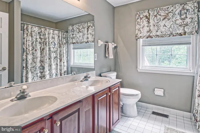 a bathroom with a granite countertop sink toilet and mirror