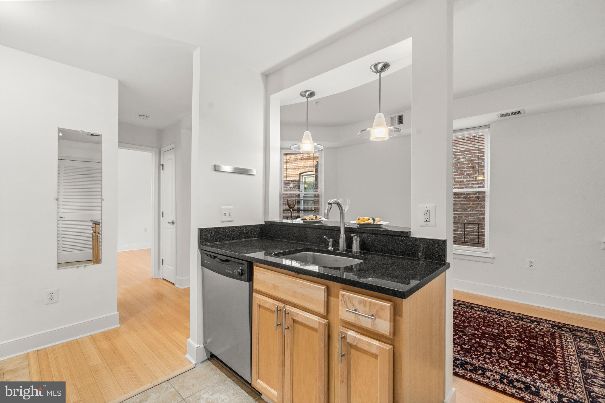 1106 Columbia Road Northwest, Unit 304 Washington, DC 20009 - Photo 12 of 25 a kitchen with granite countertop a sink and cabinets