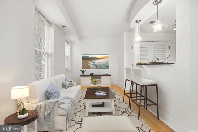 a living room with furniture a flat screen tv and a window