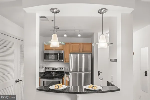 a kitchen with stainless steel appliances granite countertop a refrigerator and a sink