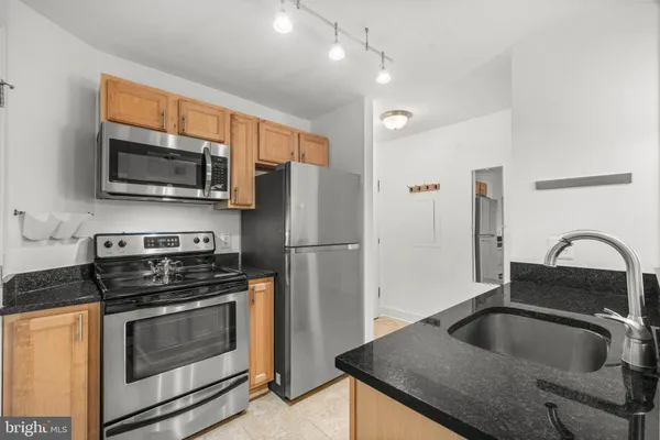 a kitchen with granite countertop a sink and stainless steel appliances