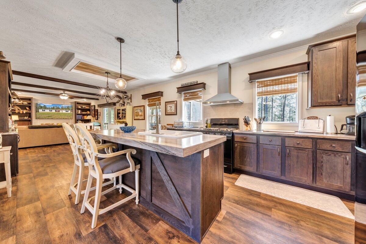 780 Adkins Road Penhook, VA 24137 - Photo 10 of 49 a kitchen with stainless steel appliances granite countertop a sink a stove and a wooden floors