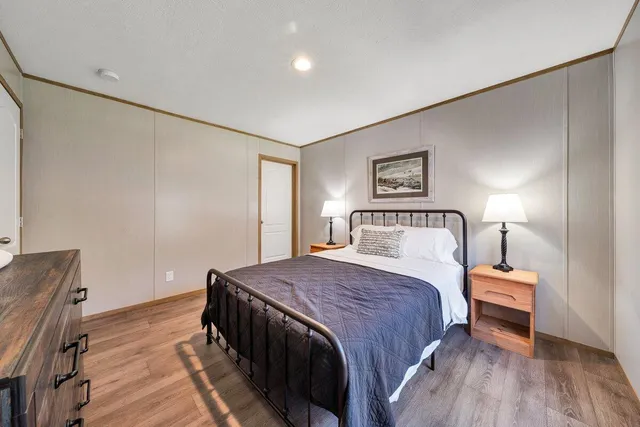 a large living room with stainless steel appliances granite countertop lots of furniture and wooden floors