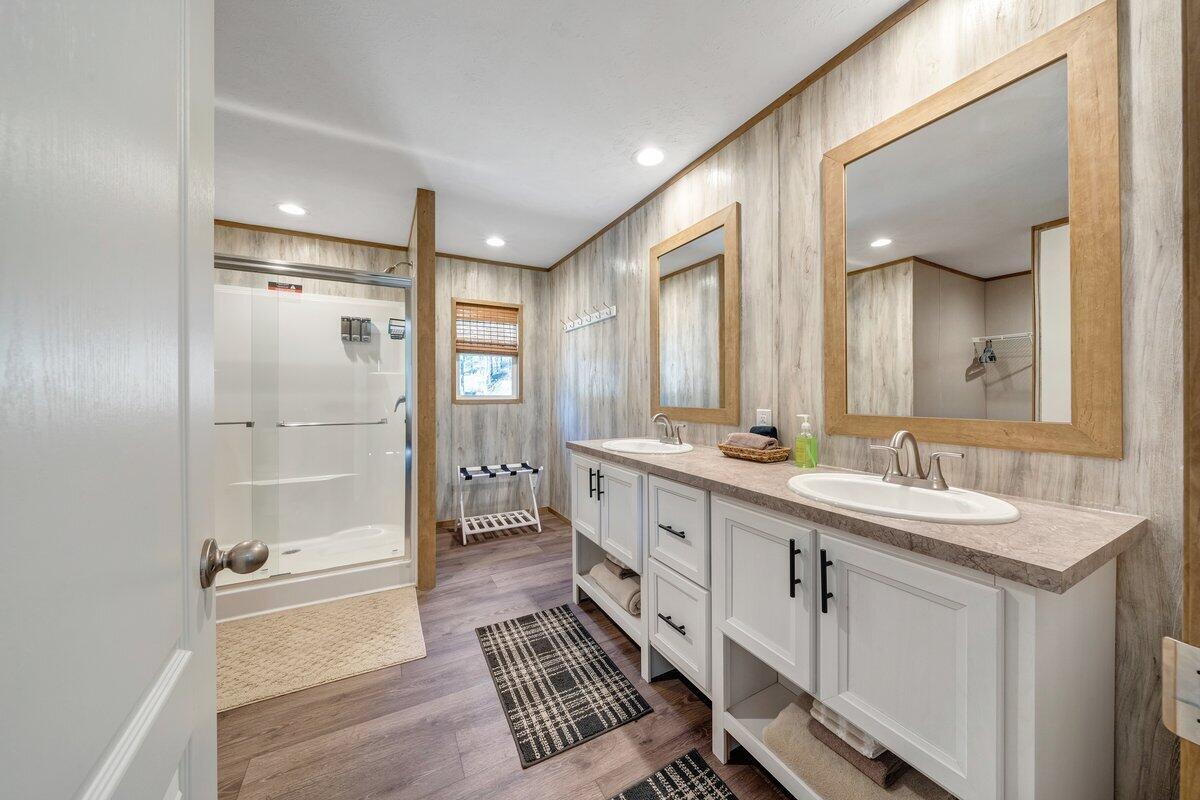 780 Adkins Road Penhook, VA 24137 - Photo 32 of 49 a bathroom with a double vanity sink a mirror and a bathtub