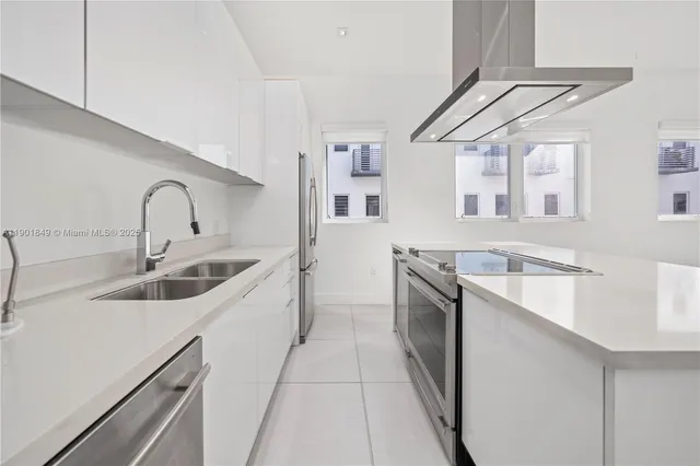 a kitchen with stainless steel appliances granite countertop a sink a stove top oven and cabinets