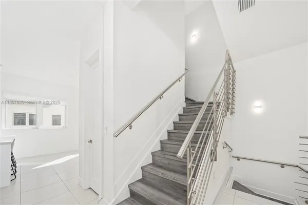 a view of staircase with white walls and windows