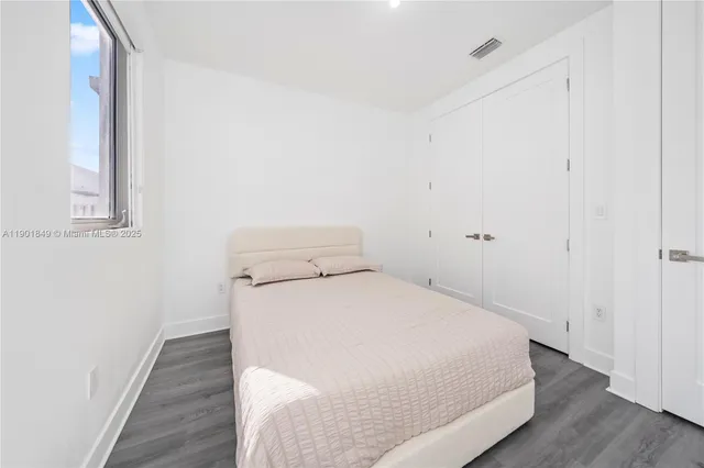 a room with a bed and wooden floor