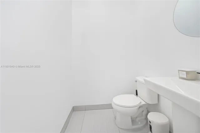 a white toilet sitting next to a white sink and vanity