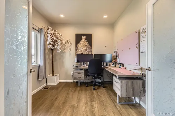a view of a workspace with furniture and wooden floor