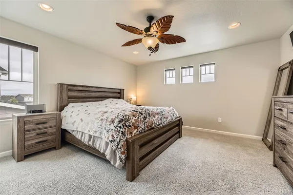 a bedroom with a bed and a ceiling fan