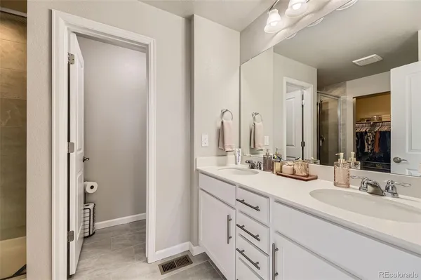 a bathroom with double vanity sinks and a mirror