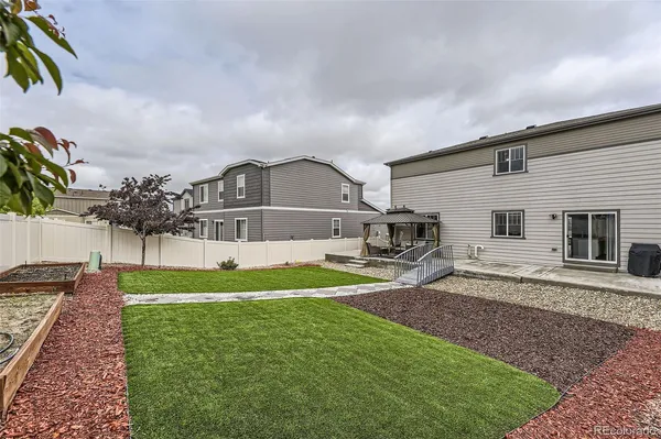 a view of a house with backyard and sitting area