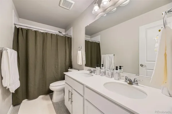 a bathroom with a double vanity sink toilet and shower