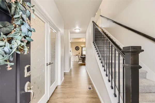 a view of a hallway with wooden floor and staircase