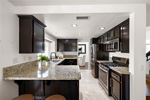 a kitchen with stainless steel appliances granite countertop a sink stove and refrigerator