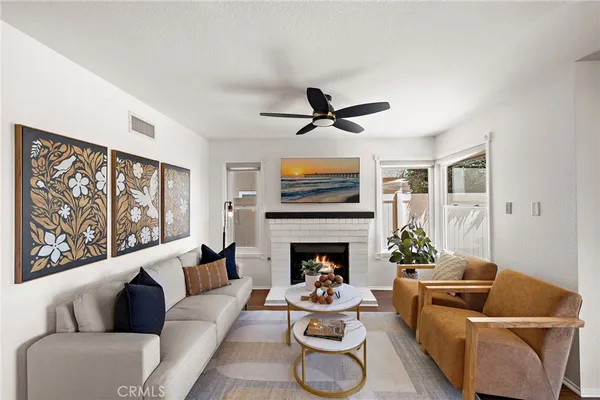 a living room with furniture kitchen view and a window