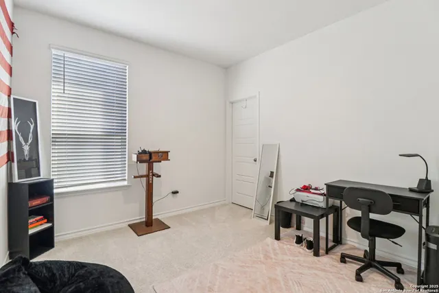 a view of a workspace with furniture and a window