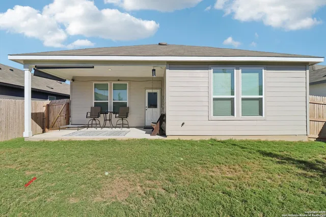 a view of a house with a patio and a yard